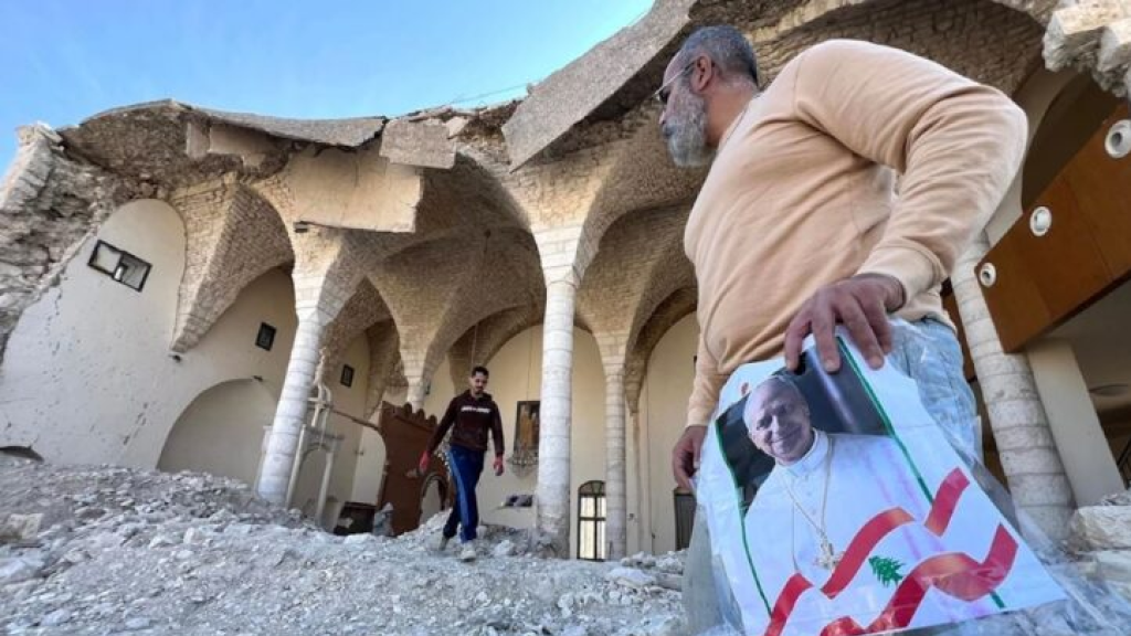 جنوبي يرفع صور البابا فوق ركام كنيسته